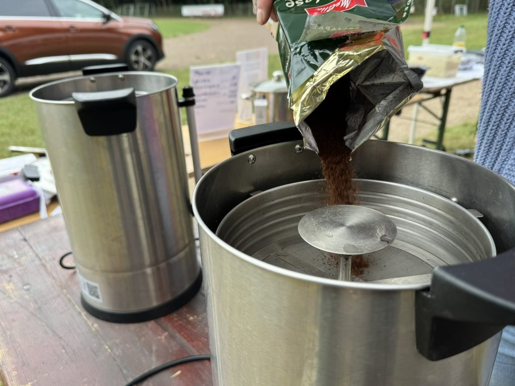 Kaffeepulver wird in eine große Kaffeemaschine gefüllt